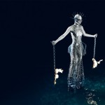 Model holding chains on fire and a metal dress